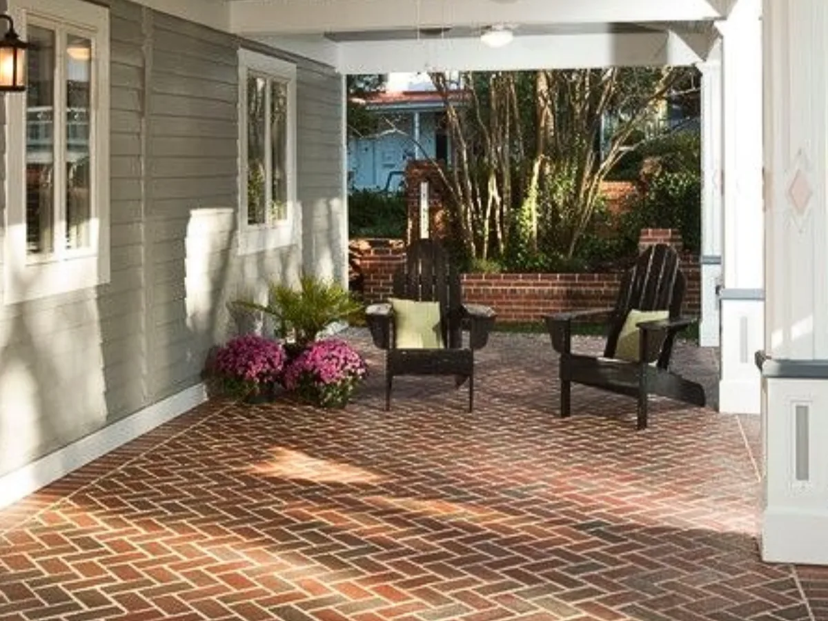 Covered porch floor of clay brick pavers in a herringbone pattern with mortar joints, brick pavers