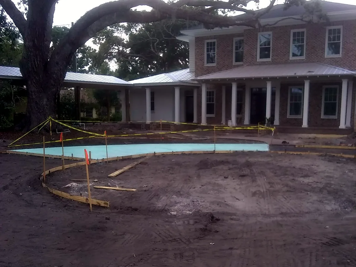 Wood forms staked out for a curved concrete driveway before the pour, concrete driveways and patios