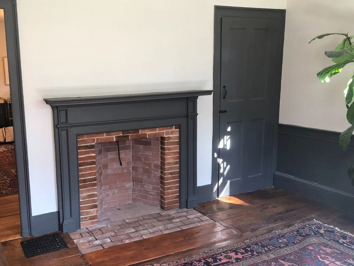 Brick fireplace with a brick firebox and a flush brick hearth inside a painted wood surround, indoor fireplaces